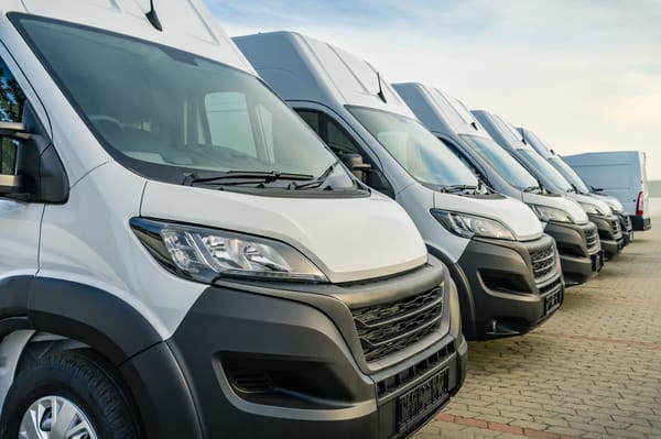 Flåde af moderne hvide varebiler klar til kørsel