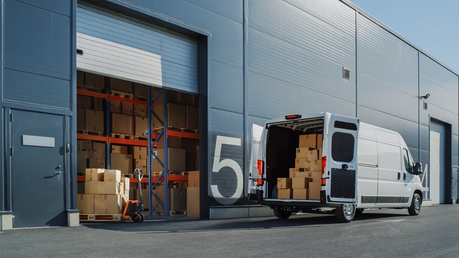 KVC Express hvid varevogn lastet ved moderne distributionscenter og lagerterminal